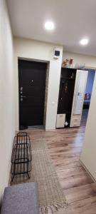 a room with a black garage door and a wooden floor at Homestay Ezerkrasts in Liepāja