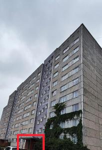 a large building with a red bus in front of it at Homestay Ezerkrasts in Liepāja