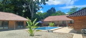a house with a swimming pool in a yard at El Sueño Belga in Golfito