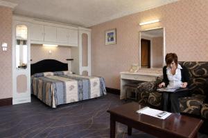 Eine Frau sitzt in einem Hotelzimmer an einem Schreibtisch in der Unterkunft The Devoncourt Resort in Exmouth