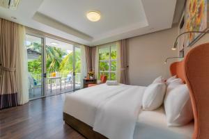 a bedroom with a white bed and a balcony at Diamond sea villa in Danang +23 photos