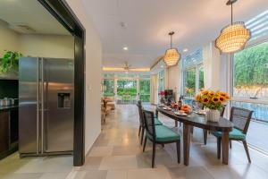 a dining room with a table and chairs and a refrigerator at Diamond sea villa in Danang