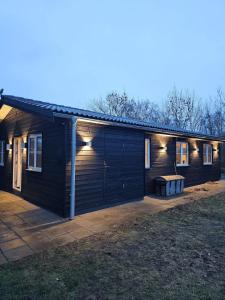 a wooden house with lights on the side of it at NordNest in Frederiksværk +6 photos