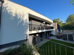an apartment building with a balcony and a yard at Sirály apartman in Keszthely