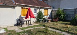 a red umbrella in the yard of a house at Ma petite maison in Vierzon