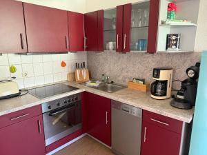a kitchen with red cabinets and a sink at Crampas 1 in Sassnitz