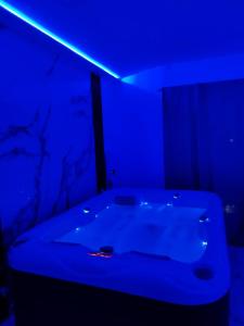 a blue room with a tub with a blue light at Om relax apartman in Prijedor