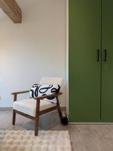 a chair and a cat sitting next to a green door at ALP'INN Les Gets in Les Gets