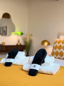 a group of towels on a bed with slippers on them at ALP'INN Les Gets in Les Gets