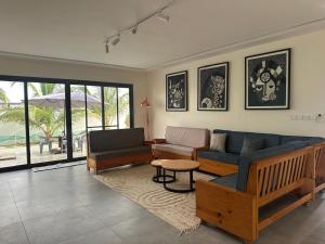 a living room with a couch and a table at Ker Ar Mor - Villa 3 chambres avec piscine privée à Nguerigne in Sintiân