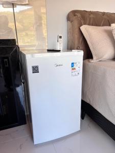 a white refrigerator sitting next to a bed at Sítio Volta Fria in Pedra Menina