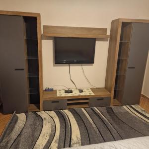 a bedroom with a bed with a tv on the wall at Samu lakóház in Balatonberény