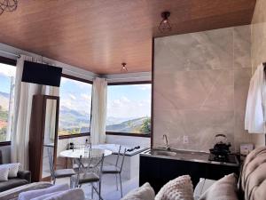 a kitchen with a large window and a table and chairs at Sítio Volta Fria in Pedra Menina