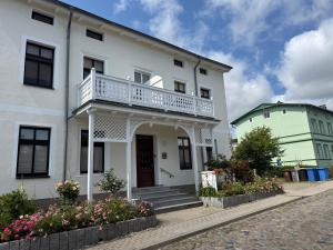 a white house with a balcony on it at Crampas 1 in Sassnitz