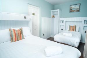 two white beds in a room with blue walls at Apartment 1 in Doolin