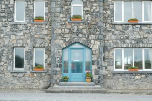 a blue door on the side of a stone building at Apartment 1 in Doolin