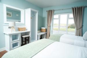 a bedroom with two beds and a window at Apartment 1 in Doolin