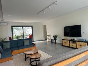a living room with a couch and a flat screen tv at Ker Ar Mor - Villa 3 chambres avec piscine privée à Nguerigne in Sintiân
