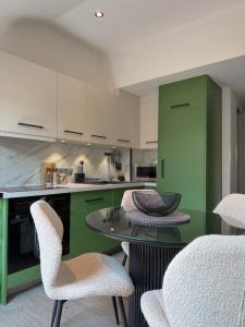 a kitchen with green cabinets and a table and chairs at ALP'INN Les Gets in Les Gets