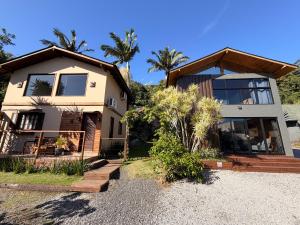 a house with palm trees in front of it at Pousada Ilha da Magia in Florianópolis