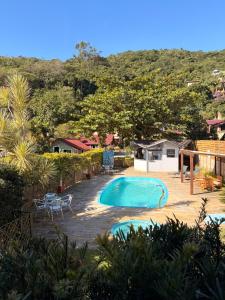 a swimming pool with a table and chairs in a yard at Pousada Ilha da Magia in Florianópolis