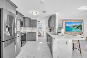 a kitchen with stainless steel appliances and a living room at 6BR Villa Tropical Haven Private Pool & BBQ in Homestead