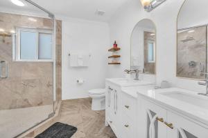 a bathroom with a toilet and a sink and a shower at 6BR Villa Tropical Haven Private Pool & BBQ in Homestead
