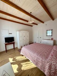 a bedroom with a large bed and a television at Casa Vacanze LA CIMINEA in Erula