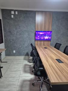 a conference room with a desk with a computer on it at Palace Hotel Jacutinga JS in Jacutinga
