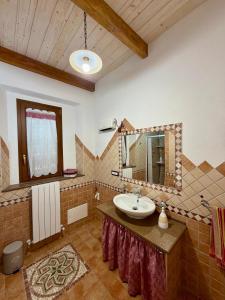 a bathroom with a sink and a mirror at Casa Vacanze LA CIMINEA in Erula +17 photos