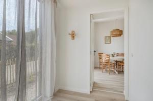 a kitchen and dining room with a table and a window at Sea & Forest Lodge in Oostkapelle