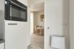 a living room with a television on top of a refrigerator at Sea & Forest Lodge in Oostkapelle
