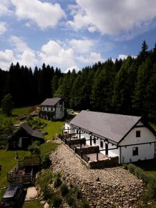 a large white building with a house and trees at Domek Przyjacielówka Ekstra -Miejsce Ciszy in Sienna