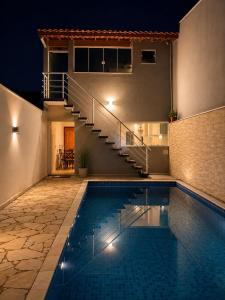 a house with a swimming pool and a staircase at Casa dos bons encontros in Santa Isabel