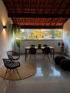 a room with a table and chairs and a large window at Casa dos bons encontros in Santa Isabel