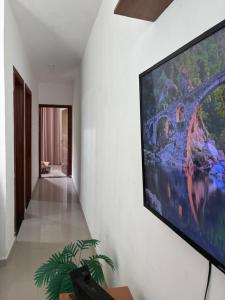 a large flat screen tv hanging on a wall at Casa dos bons encontros in Santa Isabel