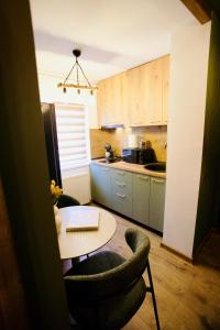 a kitchen with a table and a chair and a table at Zara Home Cozy Studio in Petroşani +20 photos