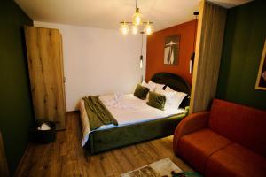 a small bedroom with a bed and a couch at Zara Home Cozy Studio in Petroşani