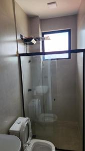 ein Badezimmer mit Toilette und Glasdusche in der Unterkunft studio cotia in Cotia