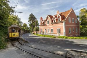 a yellow train on the tracks next to a house at Chalet Santo António in Sintra