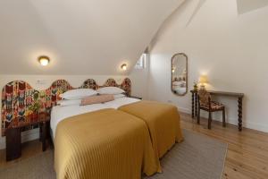 a bedroom with a large bed with a yellow blanket at Chalet Santo António in Sintra