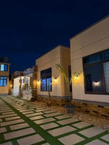 a row of buildings at night with a palm tree at Residence Cottages in Morogoro