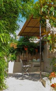 a table and a chair under an umbrella at Le jardin du Castillon in Paradou