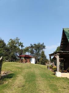 a grassy field with a building in the background at San Pedro Atmatla Zacatlan Cabins in Zacatlán