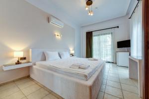 a white bedroom with a large bed and a television at Lagoonia Sun Hotel in Fethiye +57 photos