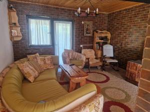 a living room with a couch and a brick wall at Casa Cuca Macai in Lăunele