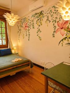 a bedroom with a bed and flowers on the wall at Youki Haus Hostel in Montevideo