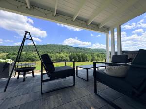 a porch with chairs and a swing and a view at Domek Veron 2 in Hańczowa