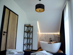 a bathroom with a white tub and a mirror at Domek Veron 2 in Hańczowa
