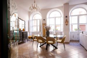 a dining room with a table and chairs and windows at La Casa de Claudio Marcelo in Córdoba